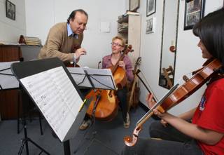 Oscar Carrescia makes a point while conducting for his wife Elena Kapustina, center, on cello and student Leah Marimo Woods.