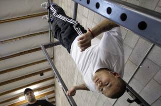 WBA interim super lightweight champion Marcos Maidana of Argentina hangs upside down during a workout at Barry's Boxing Center on Wednesday, March 24, 2010. Assistant trainer Cristian Rodriguez looks on at left. Maidana will defend his title against Victor Cayo of the Dominican Republic at the Hard Rock on Saturday.