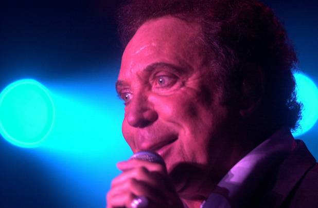 British performer Tom Jones sings on an open-air stage during ...