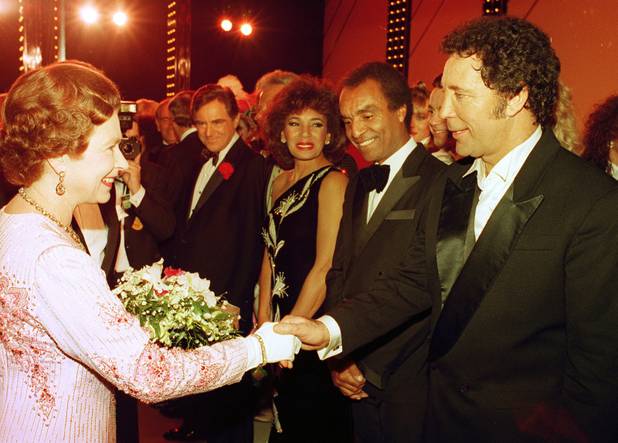 British singer Tom Jones, right, shakes hands with Britain's Queen ...