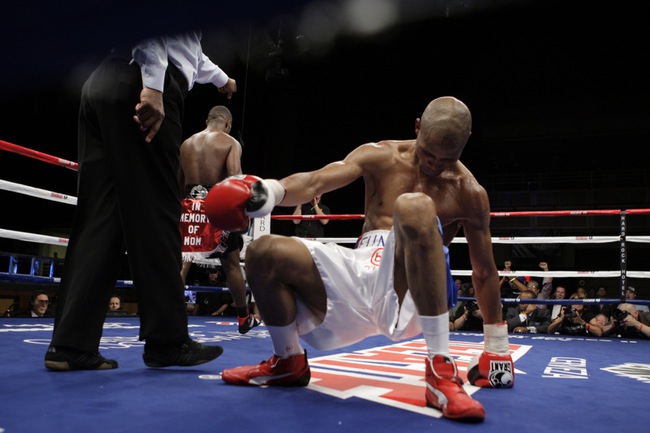 Lightweight boxer Ali Funeka of South Africa gets off the canvas after being knocked down by Joan Guzman of the Dominican Republic during their fight at the Hard Rock on Saturday March 27, 2010.