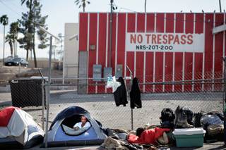 A homeless man camps with others inside tents along Foremaster Lane between Las Vegas Boulevard North and Main Street in Las Vegas on Thursday, April 2, 2009. 