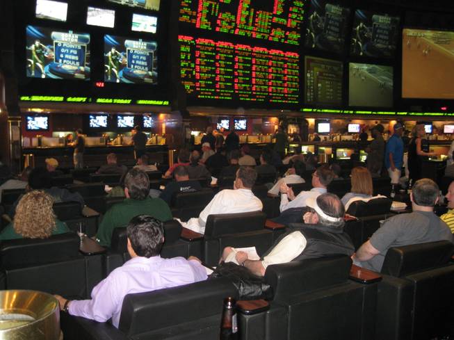 Bettors take in basketball games at the LVH Superbook.
