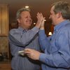 Cam Walker receives a high five from his brother-in-law, Doug Broadbent, left, after the announcement that Walker received the most votes in the early voting of the primary election for a seat on the Boulder City Council during his watch party Tuesday night at Kirk and Vivian Harrison's home. 