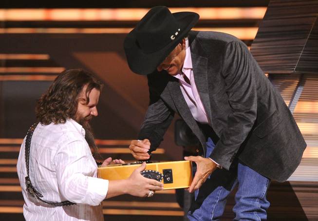 George Strait , right, signs an autograph for performer Jamey Johnson at the ACM Artist of the Decade All Star Concert. George Strait is the recipient of the Artist of the Decade award. 