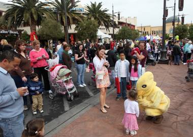 Visitors to Town Square greet the Easter chick on Saturday morning. Town Square had games, booths and more than 35,000 eggs to be collected.