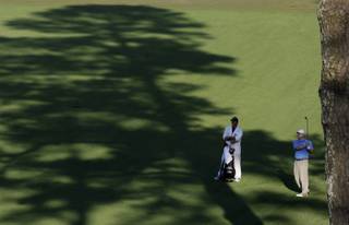 Chad Campbell watches his drive with his caddie Judd Burkett on the 15th fairway during the third round of the Masters golf tournament at the Augusta National Golf Club in Augusta, Ga., Saturday.