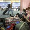 Zoe Dyer, right, a teacher form Newcastle, England, updates her Facebook page on her mobile phone ("still at the airport") while waiting with her boyfriend and other tourists at McCarran International Airport on Wednesday. As air travel resumed over Europe, tourists stranded in Las Vegas made their way to the airport to try to get flights home.