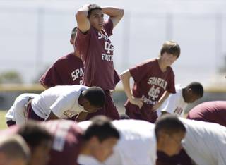 Quarterback Gerard Martinez, center, takes a breather after running drills during a spring football practice at Cimarron-Memorial High School Monday, April 26, 2010. Martinez led The Meadows to the 2A title as a freshman in 2008 and sat out last year after transferring to Cimarron.