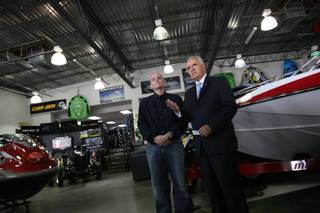 Gov. Jim Gibbons, right, and Dan Boyle, owner of ProShop Motorsports and Marine, discuss the impact of higher taxes on small businesses during a press conference at Boyle's Henderson showroom on Friday.
