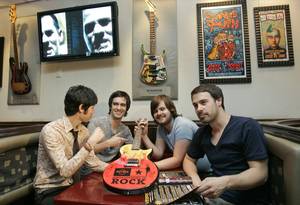 In this photo provided by Hard Rock International, members of the band Panic At The Disco, from left, Ryan Ross, Brendon Urie, Spencer Smith and Jon Walker look over the donated Hard Rock's 2008 Ambassadors of Rock guitar at the Hard Rock Cafe, Thursday, Oct. 9, 2008, in Las Vegas.