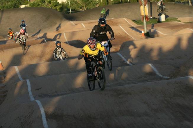 Metro Officer, Michael Kaczmerk, foreground, rides with Boulder City youth during the annual BMX Is Not A Crime event Friday night.