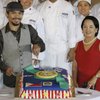 Philippine President Gloria Macapagal Arroyo, right, poses as Filipino boxing star Manny Pacquiao cuts a cake given to him at the Malacanang presidential palace in Manila, Philippines, on Monday. Pacquiao, who stunned Ricky Hatton in the second round of their title fight on May 3 in Las Vegas, was greeted by huge crowds at his homecoming.