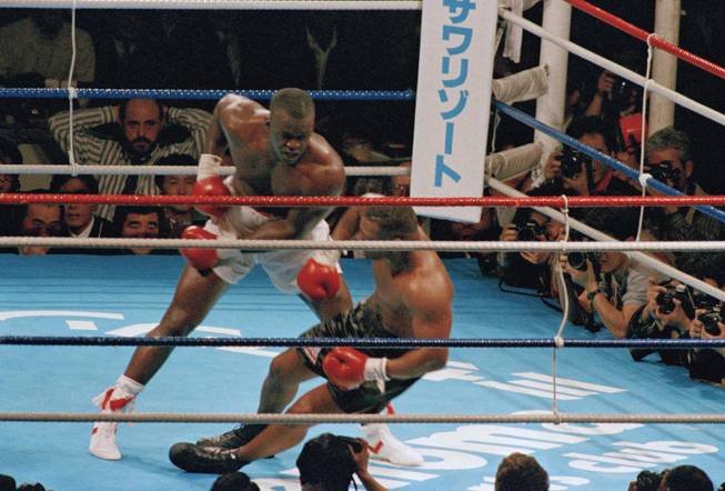 James Douglas follows with a left, dropping Mike Tyson to the canvas in the 10th round of a scheduled 12-round heavyweight champion bout at the Tokyo Dome Sunday 12, 1990. Douglas' victory goes down as one of sports' biggest upsets ever.