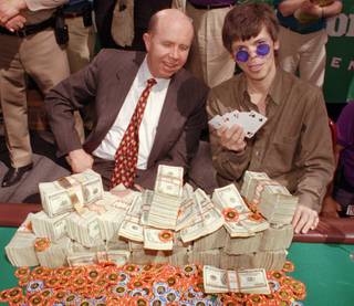 Stu Ungar, a 43-year-old professional gambler from Las Vegas, right, holds up his winning hand during the championship finals in the World Series of Poker, Thursday, May 15, 1997, in Las Vegas. Jack Binion, co-president and part owner of Binion's Horseshoe & Casino where the tournament was being held, watches Ungar after presenting him with his $1 million winnings.