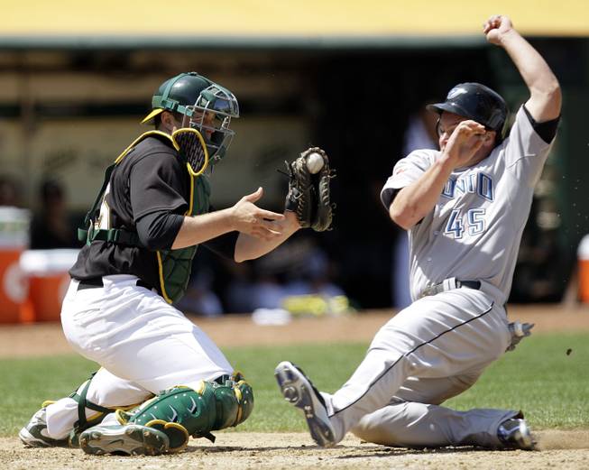 Oakland Athletics catcher Landon Powell, left, waits to tag out Toronto Blue Jays' Travis Snider in the sixth inning of a baseball game Saturday, May 9, 2009, in Oakland, Calif.