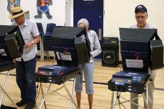 David Sweningsen joins his parents, Jean and Charles, in voting at Garrett Middle School in Boulder City.