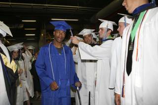 Concentrating on last minute touches, fellow classmates help LaQuan Phillips adjust his tassel before he walks on stage Tuesday for the Green Valley High 2009 graduation ceremony at the Thomas & Mack Center.