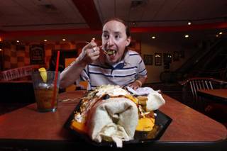 Steven Miller, 25, of Houston, TX, attempts to conquer the B3 Burrito, a massive six-pound, 24 inch burrito, at the NASCAR Cafe in the Sahara Friday, June 19, 2009. Many have tried to eat it, few have succeeded. 
