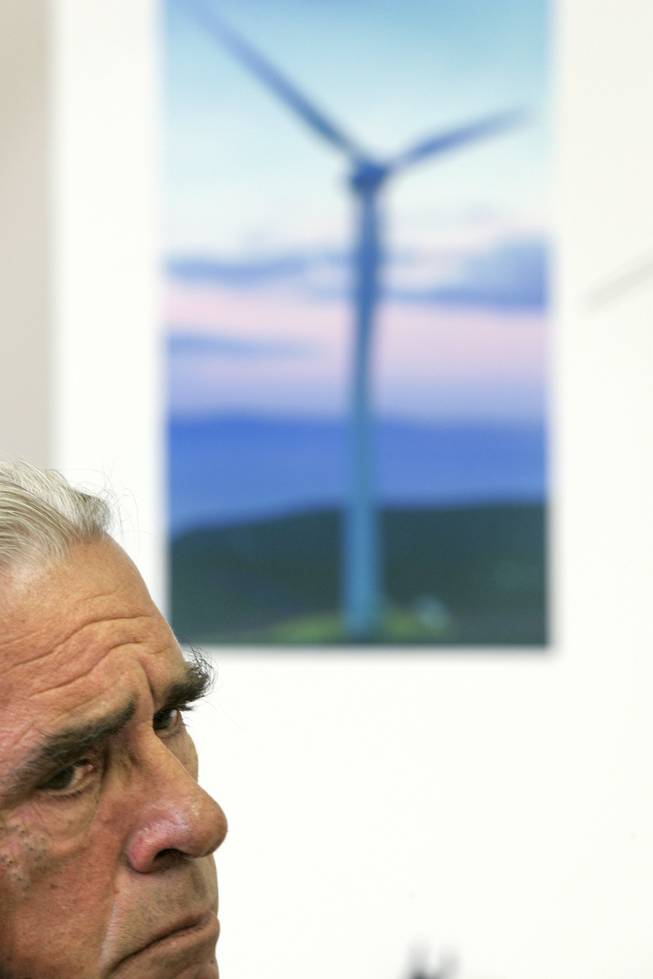 Searchlight resident George Beyer listens while sitting next to a photo of a wind turbine during a Searchlight Town Hall Meeting at the Searchlight Community Center about a proposed wind energy project Thursday, June 25, 2009. 