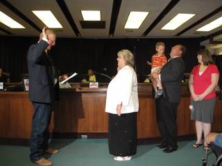 When Clark County Commissioner Tom Collins (left) asked Anita Wood to raise her hand, Wood's 4-year-old son, Jeffrey, held by his father, Doug, raised his hand as well, sparking laughter from the audience. Also pictured is Wood's adopted goddaughter, Jaclyn. Wood was sworn in as a member of the North Las Vegas City Council.