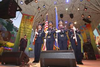 Capt. Raphael Ashe sings the national anthem as the Nellis Air Force Base honor guard, left to right, Sharif Omar, Omar Foster, Travis Skretta and Ulla Stromberg, bring out the colors to start festivities at the Fremont Street Experience. 