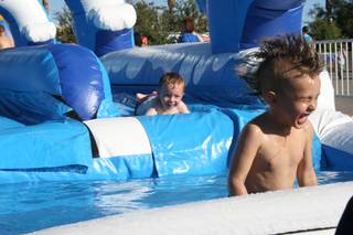 Alex Lee, 6, emerges from the water after a trip down the inflatable slip-and-slide at the Henderson Fourth of July festivities. 