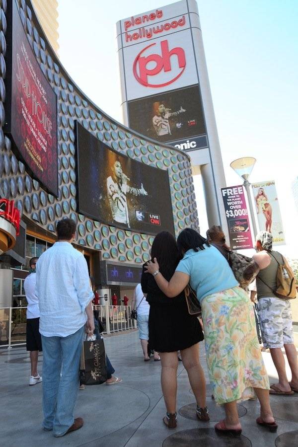 Fans watch the televised Michael Jackson memorial tribute on the video screens at Planet Hollywood.