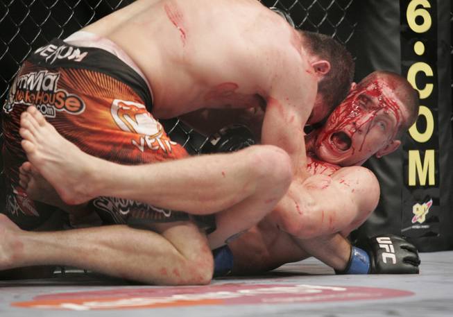 A bloodied Mac Danzig tries to escape Jim Miller during their fight at UFC 100 Saturday, July 11, 2009. Miller won by decision.