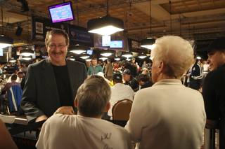 ESPN announcer Norman Chad laughs with fans standing around the tables Tuesday during the 7th day of competition at the World Series of Poker Main Event at the Rio.