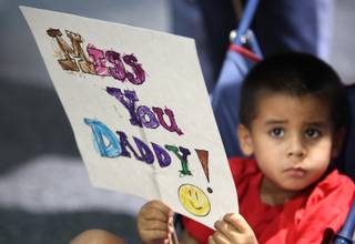Jacob Baker, 4, holds a sign up as he waits for his father, Sgt. Maj. Scott Baker, to return from a yearlong deployment from Afghanistan. Scott Baker was one member of a group of Nevada Army National Guard's Embedded Training Team soldiers who returned Wednesday to Nevada.