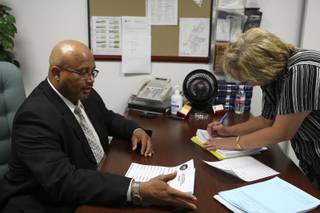 Gary Booker and paralegal Joan McConnell review pretrial conference files at his desk in the Boulder City prosecutor's office.