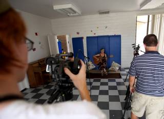 Shane Zellow, left, and Branden DeLangis, right, film Francyl Gawryn for a BCTV program promoting music classes through the Boulder City Parks and Recreation Program. Zellow and DeLangis are part of the Workforce Investment Board's summer youth jobs program.