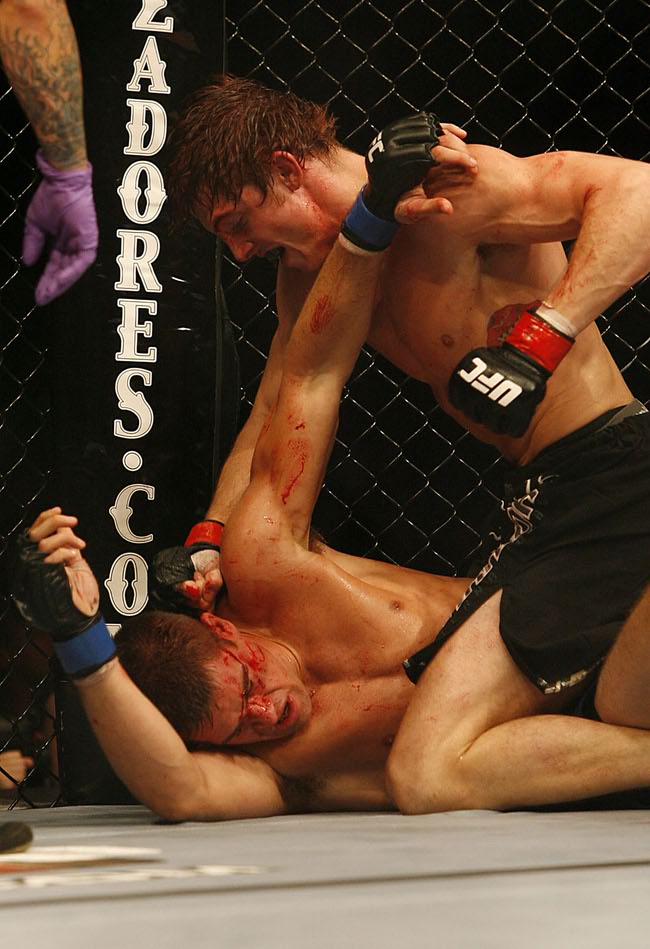 Fans of mixed martial arts and the UFC, Ultimate Fighting Championship gather at the Wachovia Center on Saturday evening August 8, 2009 for a night of fighting. Battle between welterweights Matthew Riddle and Dan Cramer. Winner is Riddle.  Riddle is on top.