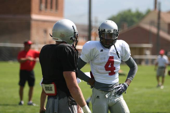 UNLV receivers Phillip Payne (4) and Ryan Wolfe talk strategy before running a skeleton drill on Friday morning during practice at Broadbent Park in Ely.