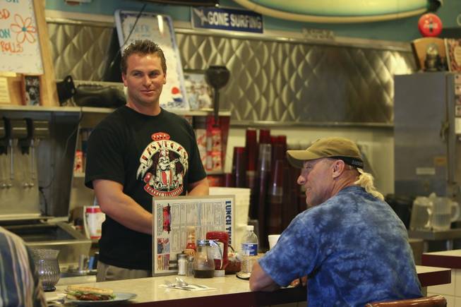 Terry Stevens visits with customers and longtime friend Jeff Patton, right, while working the counter at the Coffee Cup in Boulder City.