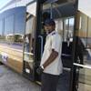 Marvin Wilkins, operator instructor for the MAX bus line, welcomes guests aboard a new ACE bus outfitted with bike racks for commuters Monday during the groundbreaking ceremony of the Bonneville Transit Center located at Casino Center Boulevard and Bonneville Avenue.