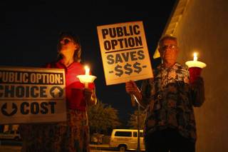 Mary Venable, who is uninsurable because of a pre-existing condition, joins Rudi Kraft in holding signs and candles in support of health care reform during a candlelight vigil Sept. 2 in Boulder City.