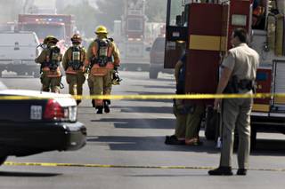 Firefighters respond to the site of a fire where one person was shot to death and a Metro Police officer was wounded in the arm in Las Vegas on Wednesday, Sept. 2, 2009. 