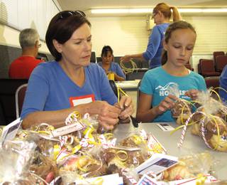 Proud Blue Star Mother Shannon Scaletta and her granddaughter, Sofie, wrap cookies to be delivered on Sept. 11.