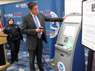 Carlos Martel, Los Angeles area port director for the U.S. Customs and Border Protection, demonstrates how to use the new Global Entry kiosk at McCarran International Airport on Wednesday.