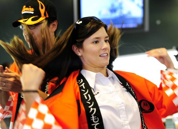 Danica Patrick puts on a happi coat during a fan ...
