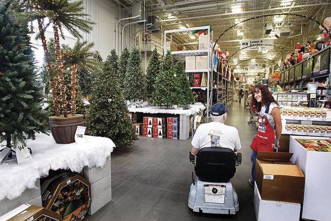 Heather Herman, a Lowe's department manager, talks with a customer Friday in the stocked and decorated Christmas aisle. 