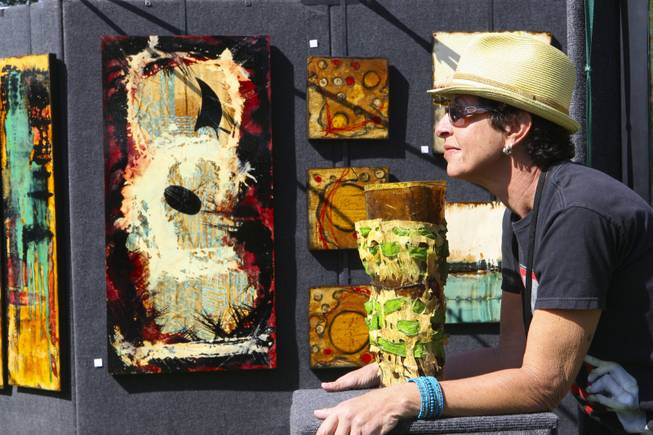 Artist Angela Alvarez relaxes in the sunshine while hoping to sell one of her two-dimensional mixed media pieces on steel Sunday during the 47th Annual Art in the Park in Boulder City.