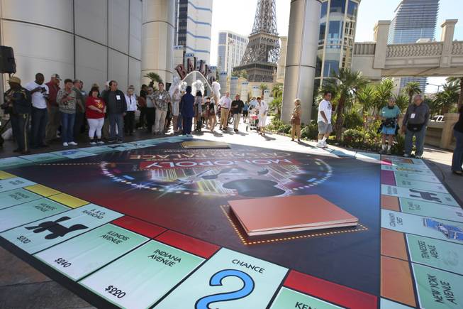 Finalists and passersby gather around the 25-by-25 foot big Monopoly ...