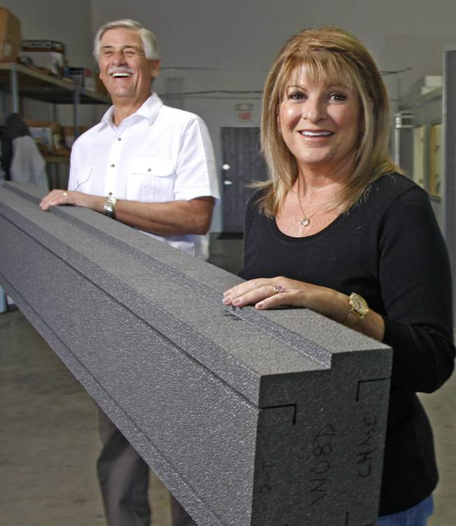 Ken and Alaina Miller, owners of Kama Energy Efficient Building Systems, hold a piece of Neopor expanded polystyrene foam. Walls made with Kama's K-tect prefabricated building sections are said to be more energy efficient than those in a standard construction home. 
