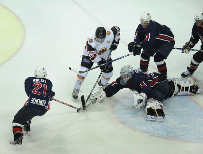 Germany's Thomas Greilinger, second left, and US Lee Sweatt and his teammates Charlie Cook, goalkeeper Jeanmarc Pelletier and Jeff Hamilton, left to right, challenge for the puk during the ice hockey Germany Cup match between Germany and USA in the Olympic hall in Munich, southern Germany, on Friday, Nov. 6, 2009. USA won the match after penalty 3-2. 