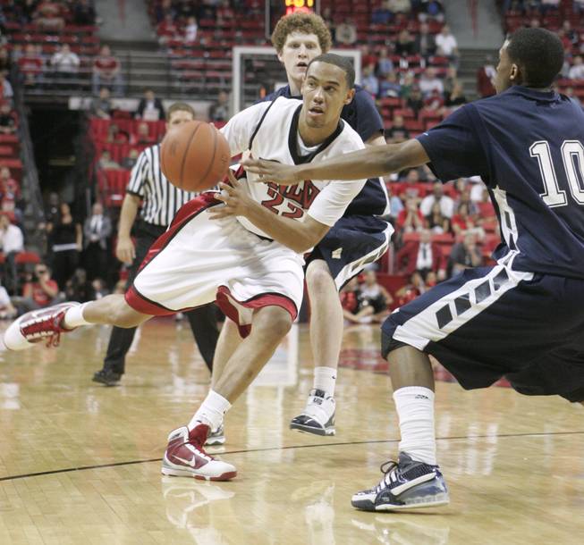 UNLV guard Chace Stanback dishes off a pass against Washburn during a preseason game Tuesday.  UNLV won the game 62-52.