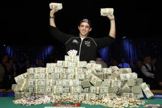 Joe Cada, a 21-year-old poker professional from Michigan, holds bundles of cash after winning $8.5 million in prize money at the World Series of Poker tournament at the Rio Tuesday Nov. 10, 2009. Darvin Moon, a 45-year-old logger from Maryland, came in second. 
