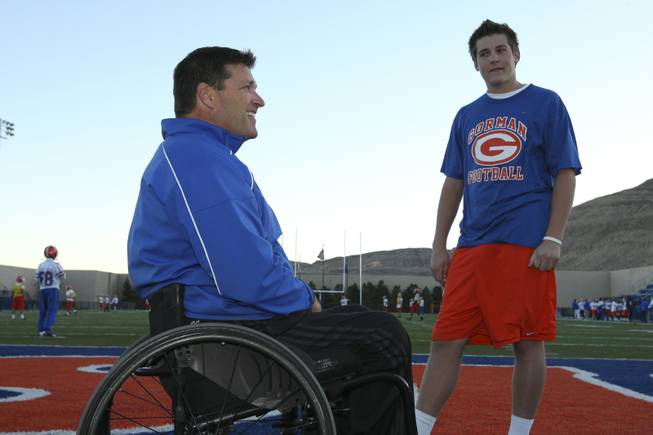 Sophomore linebacker Zach Hutchins listens to his father, freshmen linebacker coach Adam Hutchins, talk about football during practice Monday afternoon at Bishop Gorman High School.